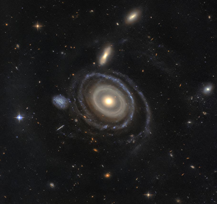Spiral galaxy with concentric rings floats on a star filled black background.