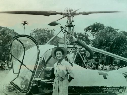 Doctor Valerie Andre in front of her helicopter with jungle in background