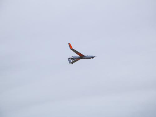 ScanEagle in flight with clouds in background.